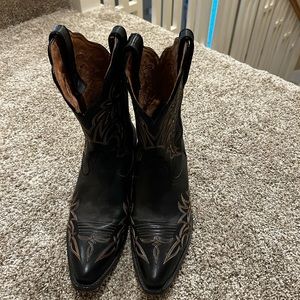 Black mid-calf cowboy boots.